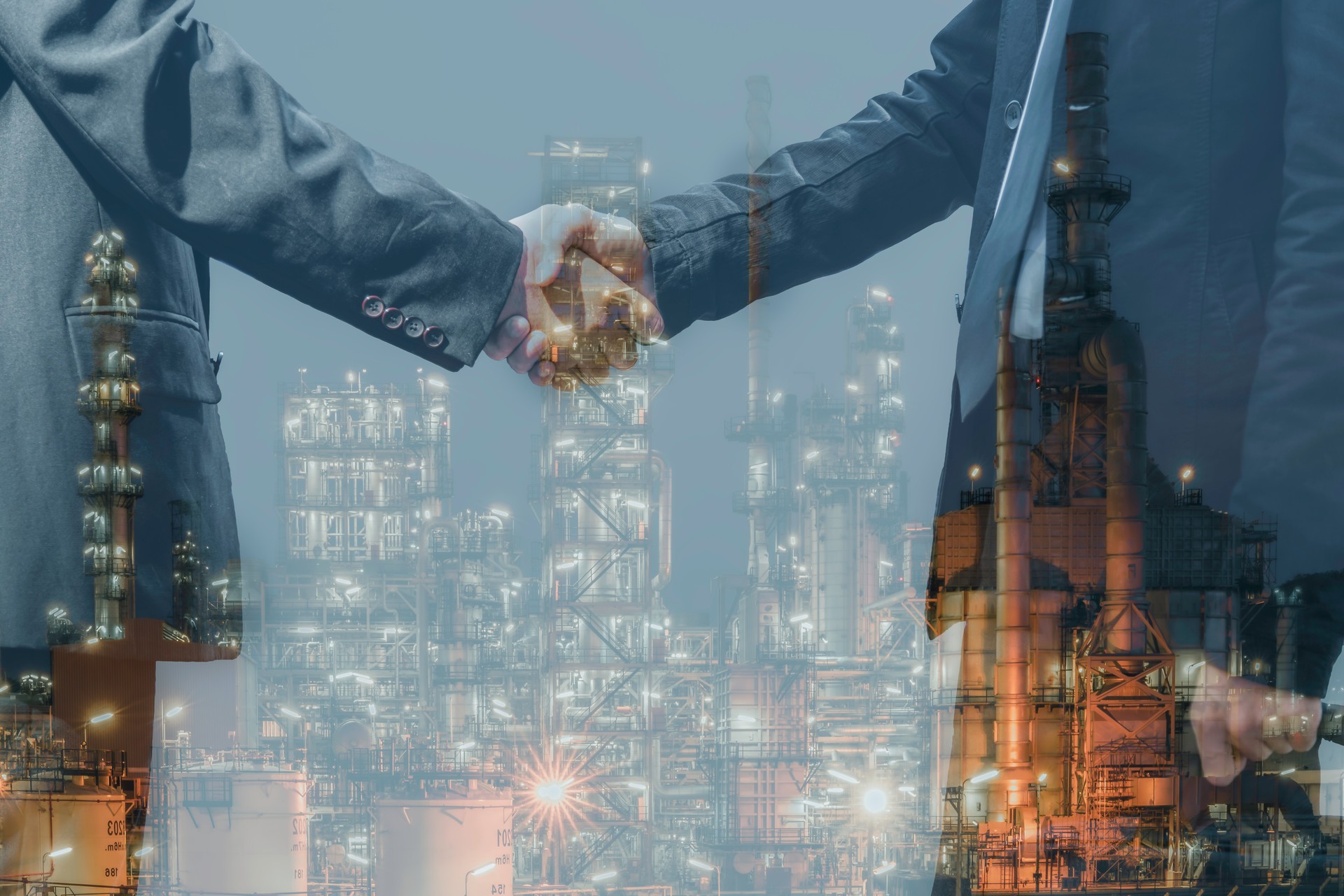 Double exposure of two businessman standing handshake on outdoors with oil and gas refinery plant petrochemical industry